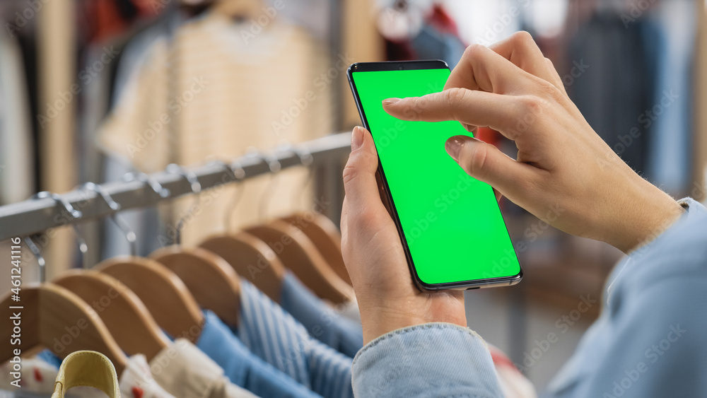 Clothing Store: Female Using Smartphone with Chroma Key Green Screen Display. Clothes Hanger with St