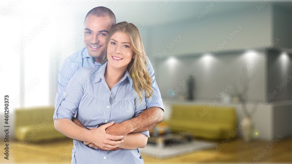 Smiling mid adult couple hugging each other and standing at home