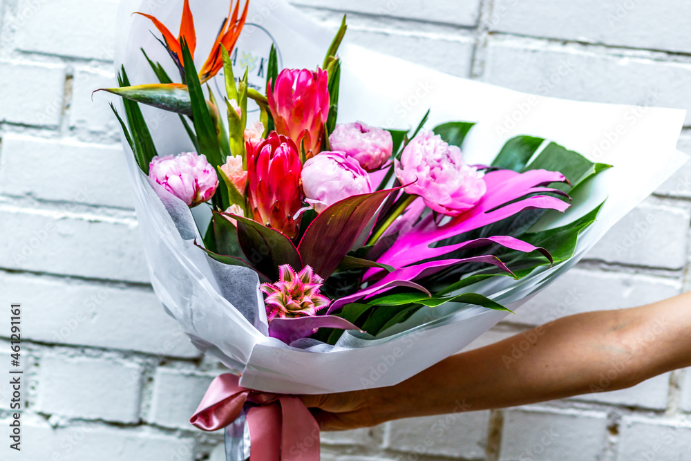 Bouquet of peonies in kraft paper on white background