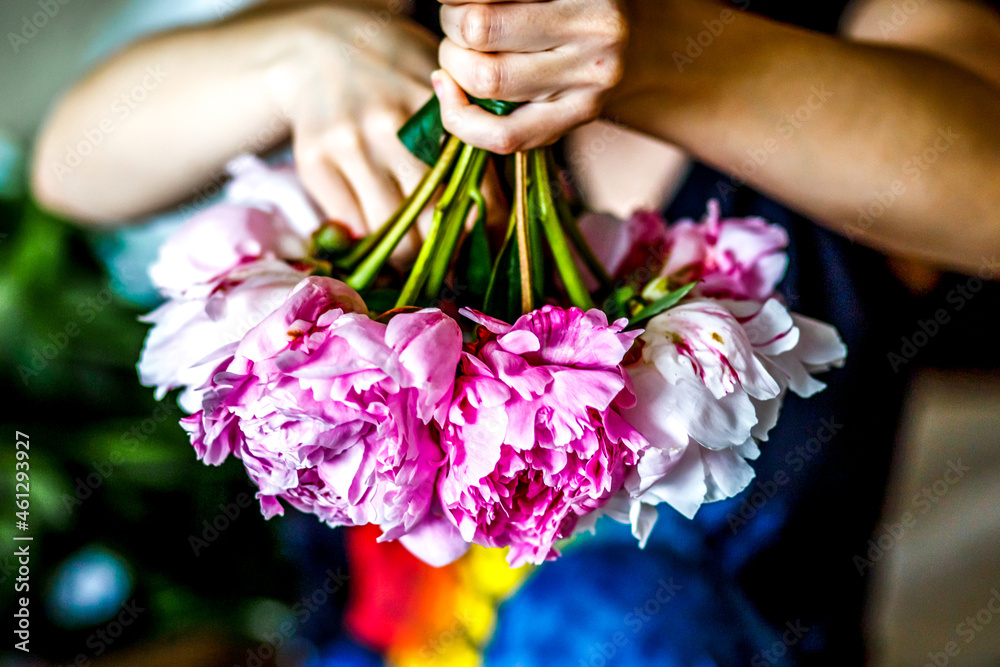 Florist making a bouguet of peonies