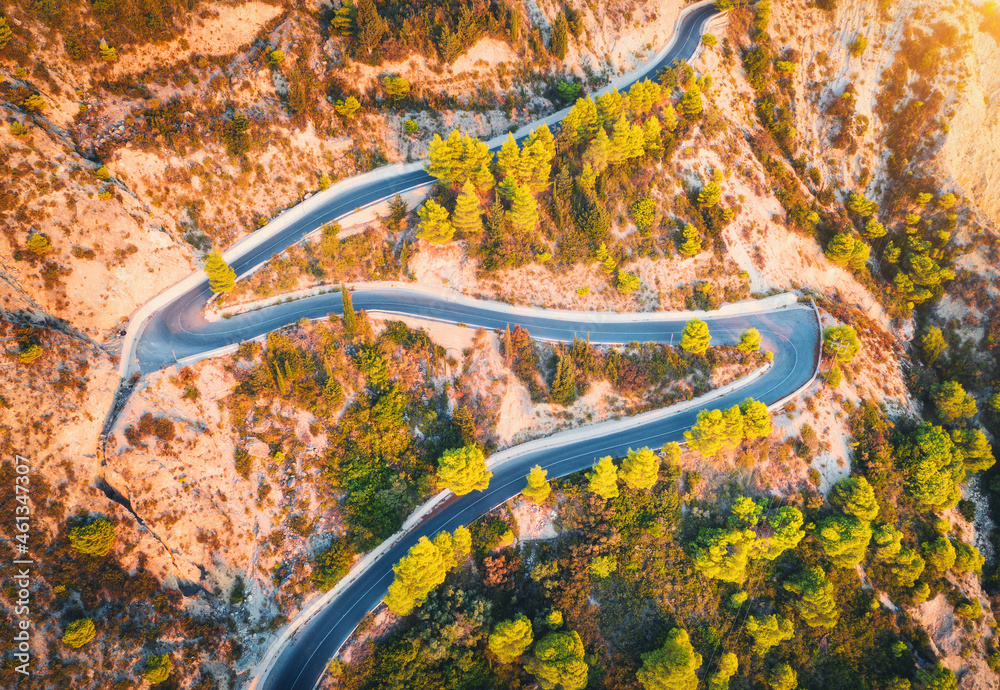 秋天日落时美丽山脉中蜿蜒道路的鸟瞰图。年山路俯视图