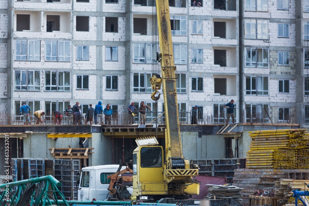 大型建筑工地，包括在建筑群上工作的几台起重机，天空晴朗