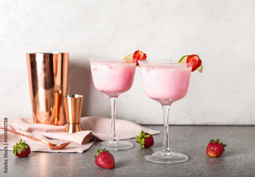 Glasses of strawberry Pina Colada cocktail and shaker on table