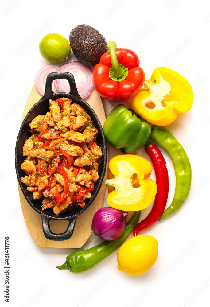 Frying pan with tasty traditional Mexican chicken Fajita and vegetables on white background