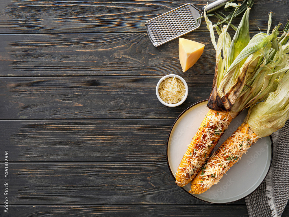 Plate with delicious Elote Mexican Street Corn on black wooden background