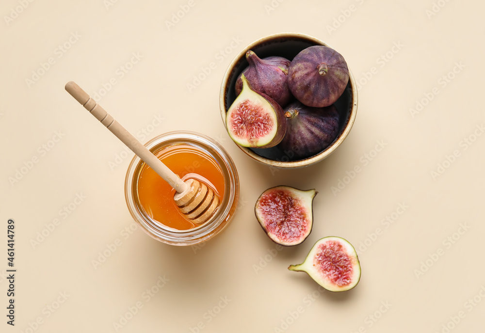 Glass jar with honey and fresh figs on color background