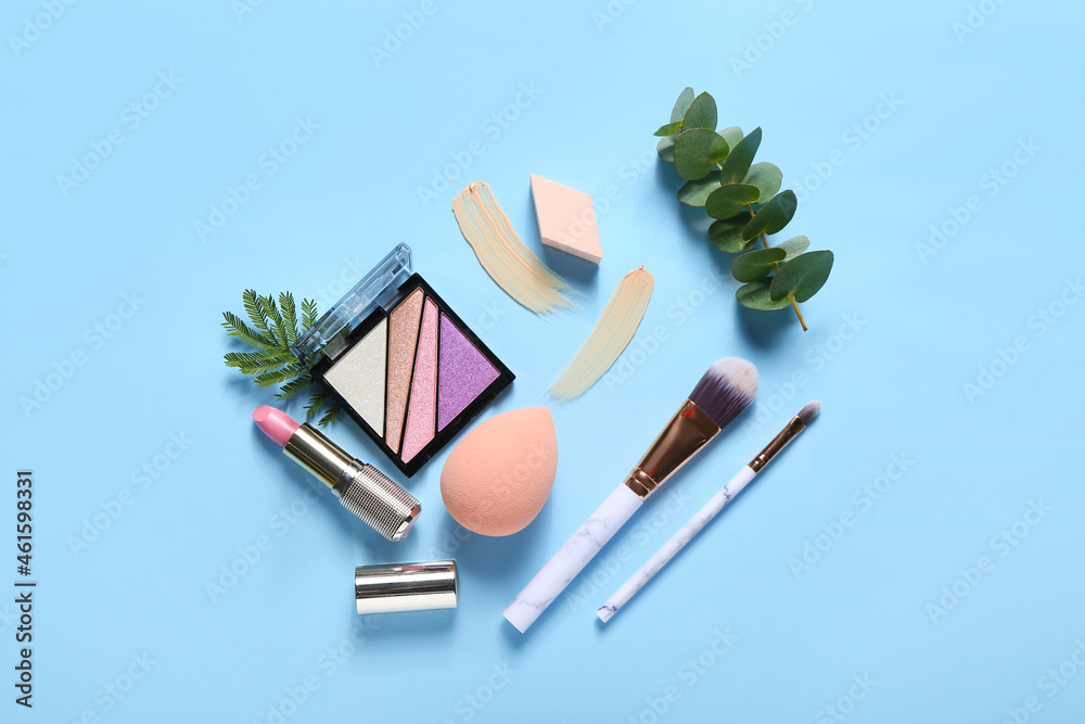 Stylish makeup sponges and decorative cosmetics on color background