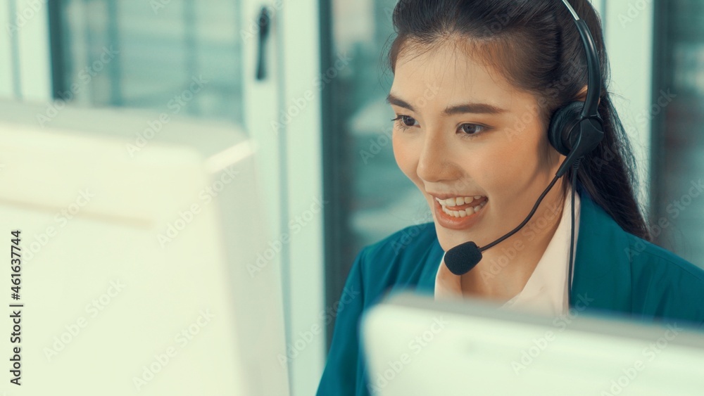 Businesswoman wearing headset working actively in office . Call center, telemarketing, customer supp