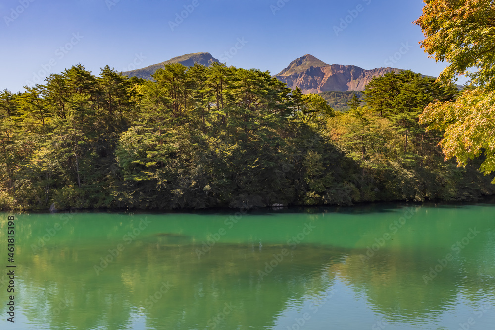 薄っすらと赤くなり始めた木と磐梯山と五色沼