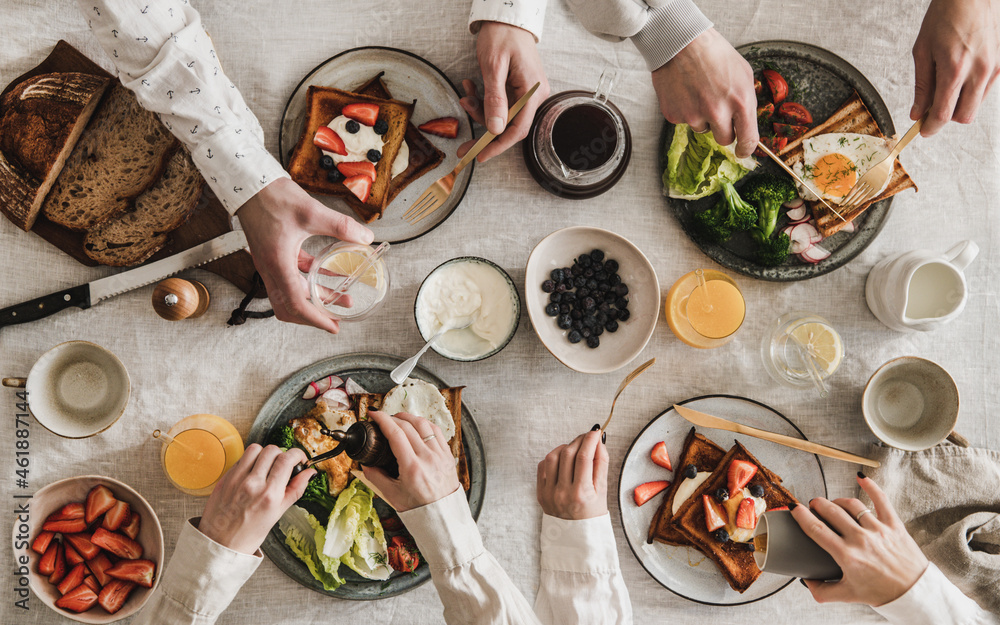 Flat-lay of peoples hands with toasts and snacks for breakfast