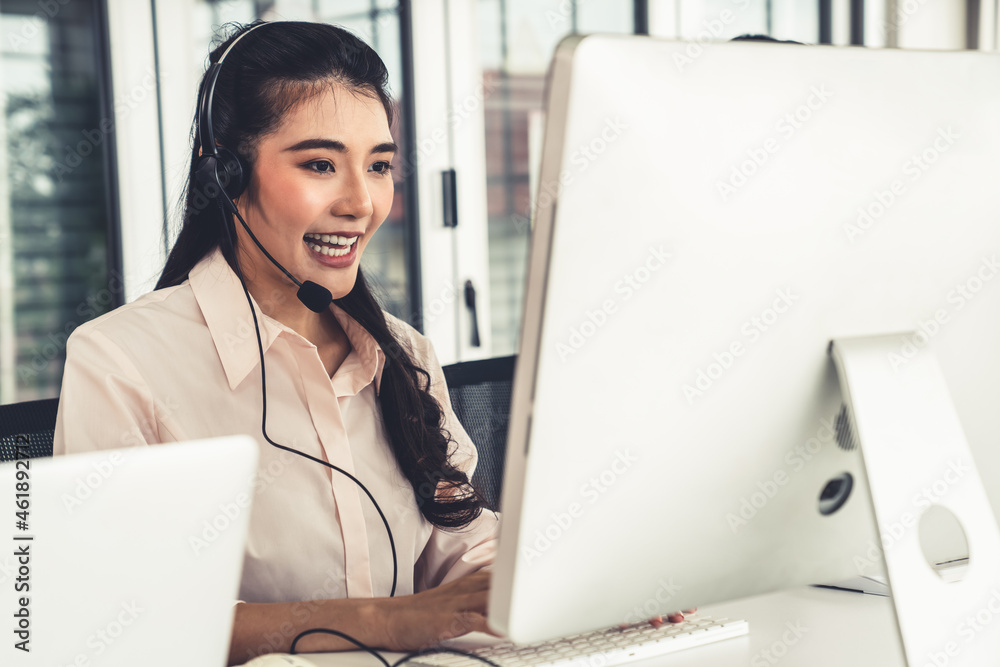 Businesswoman wearing headset working actively in office . Call center, telemarketing, customer supp