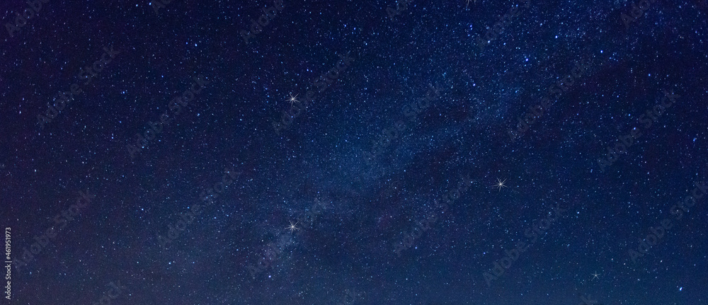 全景蓝色夜空，银河系和黑暗背景下的恒星。宇宙充满了恒星、星云和