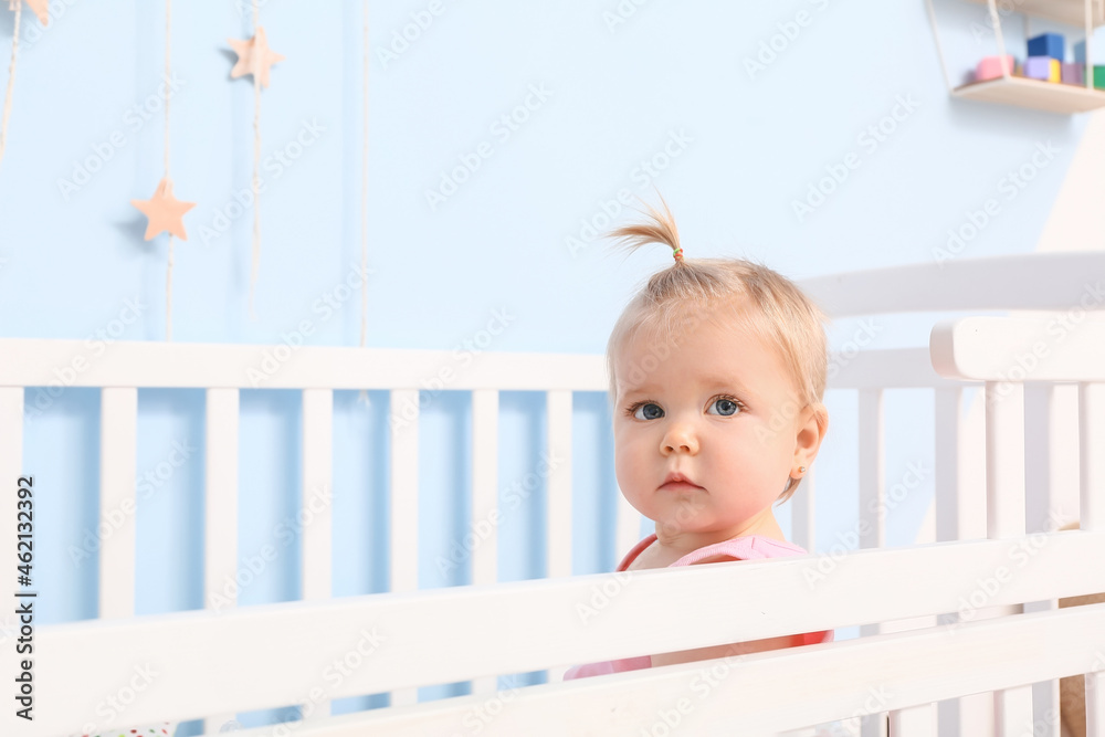 Cute baby girl in cot at home