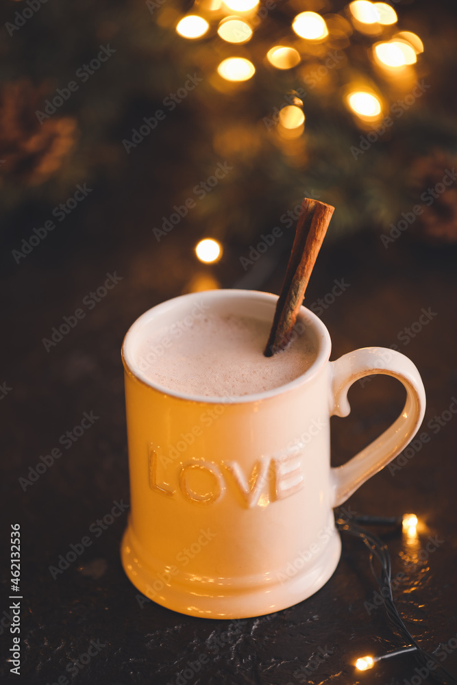 Cup of hot cocoa drink on table against blurred lights