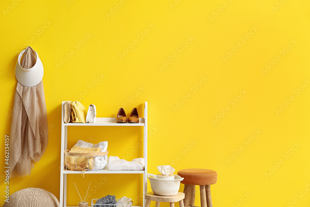 Interior of modern hallway with shelving unit and clothes