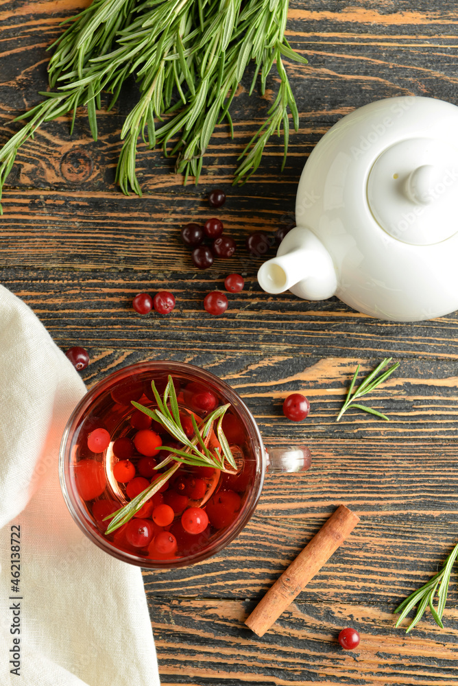 Composition with cup of tasty cranberry tea and rosemary on wooden background