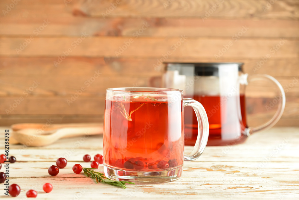 Glass cup of tasty cranberry tea on wooden table