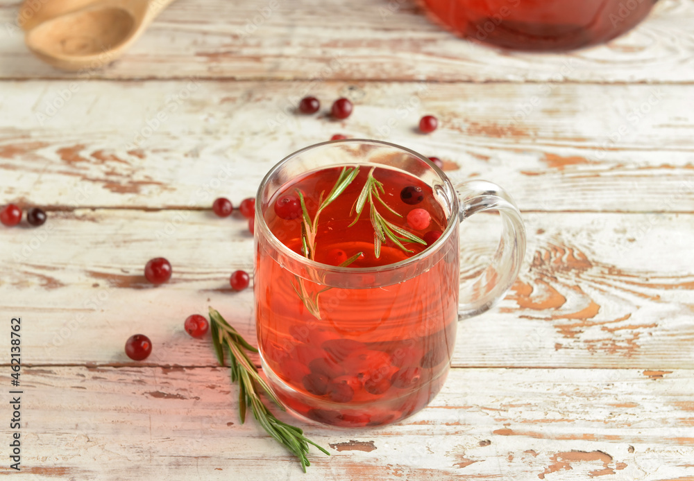 Cup of tasty cranberry tea on light wooden background