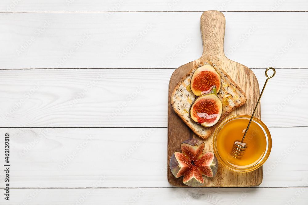 Toast with fresh ripe figs and honey on light wooden background