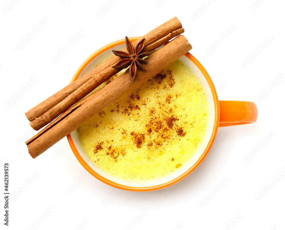 Cup of tasty turmeric latte with star anise and cinnamon on white background