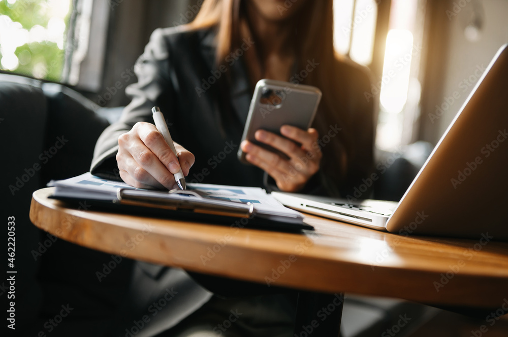 Woman using smart phone for mobile payments online shopping,omni channel,sitting on table