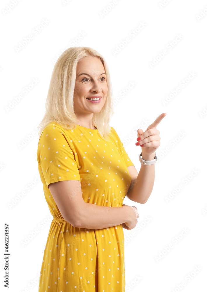 Beautiful mature woman pointing at something on white background