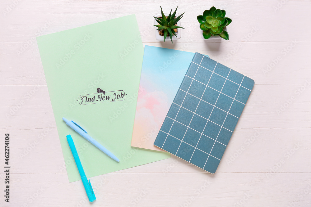 Paper sheet with text FIND NEW JOB and stationery on white wooden background. New year goals