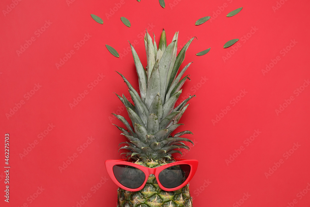 Creative composition with ripe pineapple and sunglasses on color background