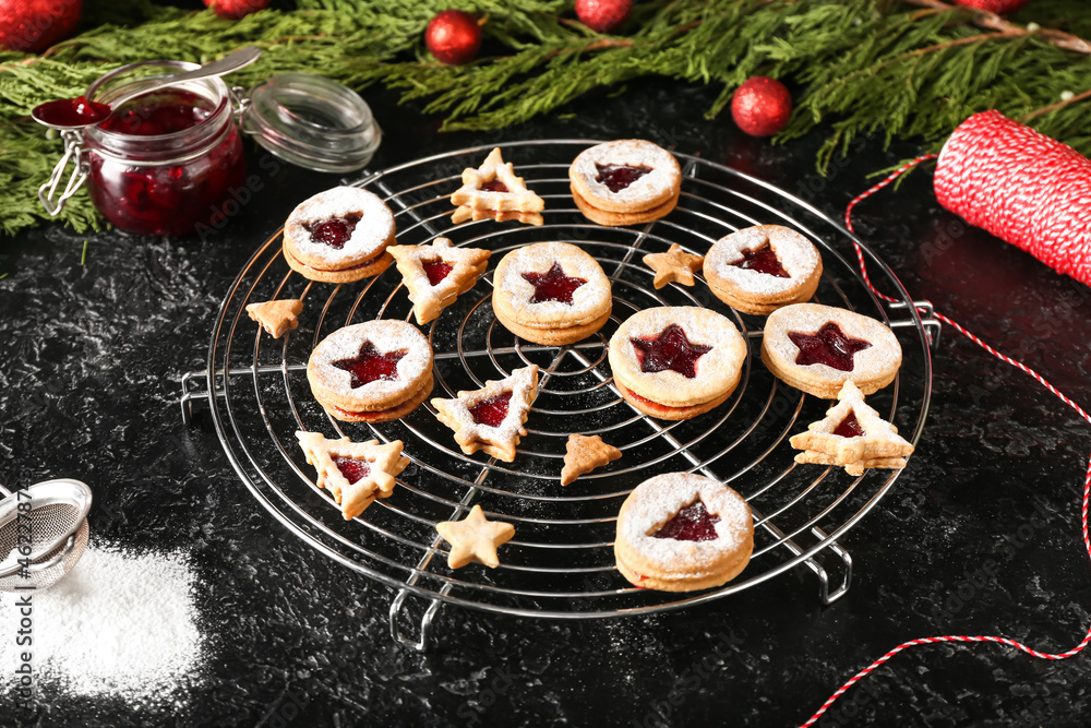 Cooling rack with traditional Linzer cookies on dark background