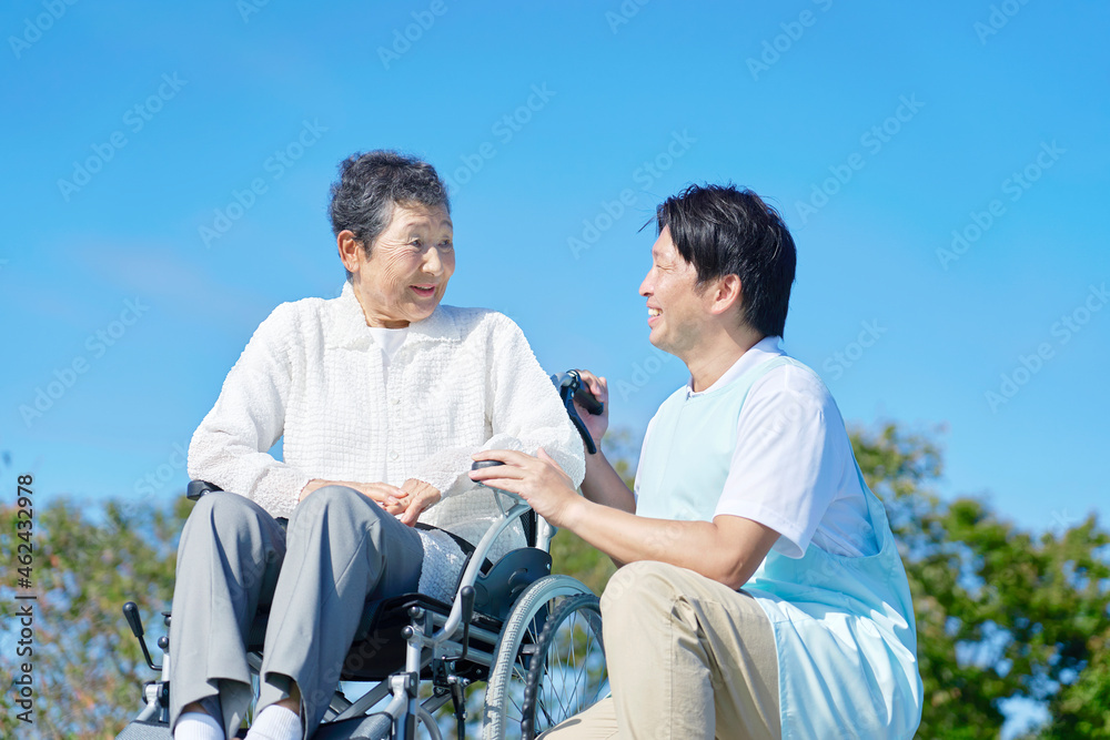 介護士と車椅子に乗る高齢者