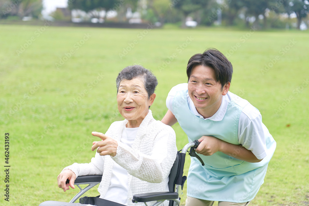 介護士と車椅子に乗る高齢者