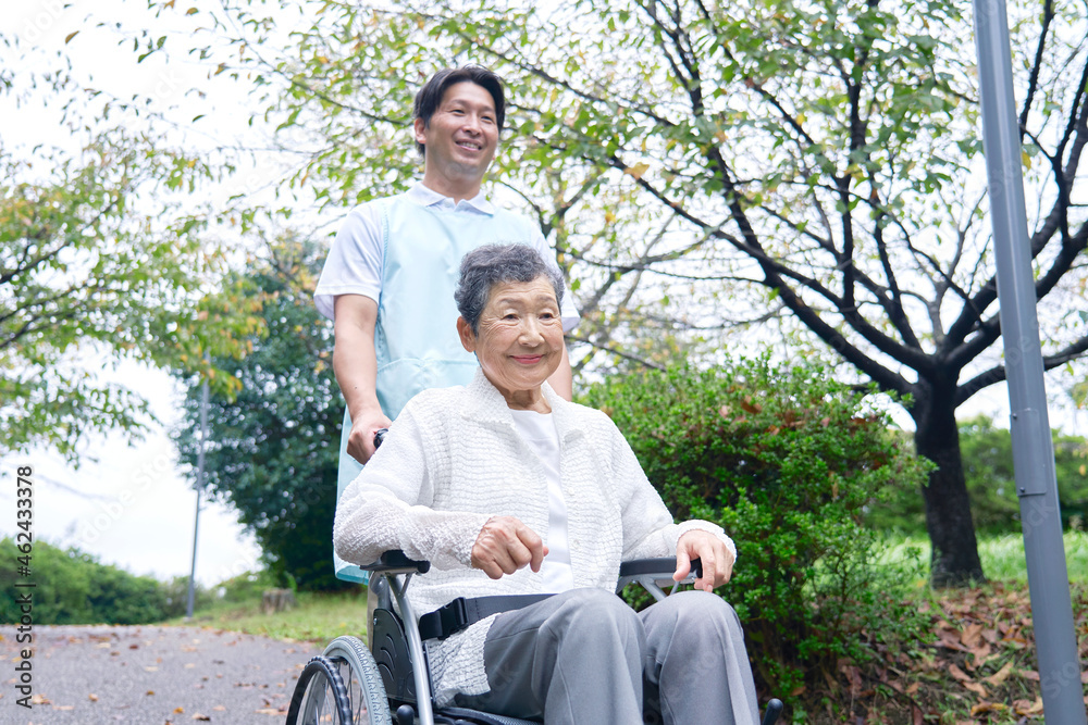 介護士と車椅子に乗る高齢者