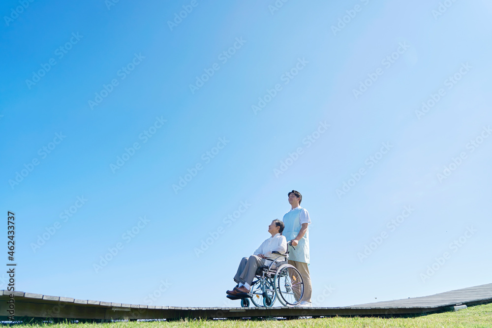 介護士と車椅子に乗る高齢者