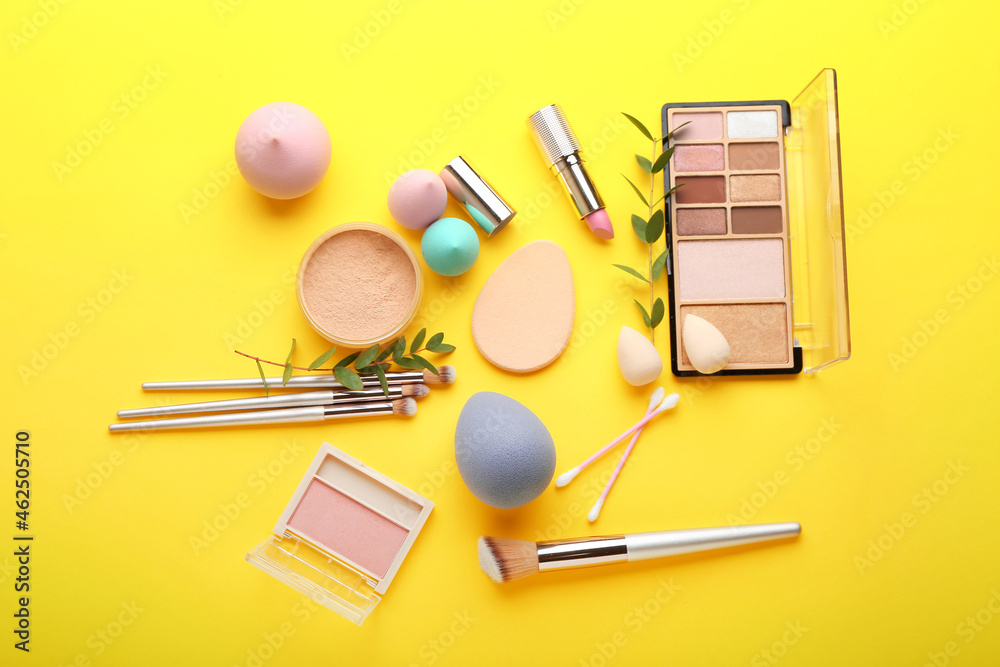 Stylish makeup sponges and decorative cosmetics on color background