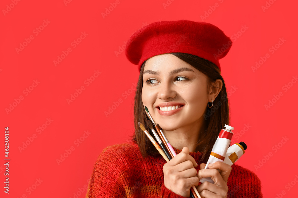 Young female artist on color background