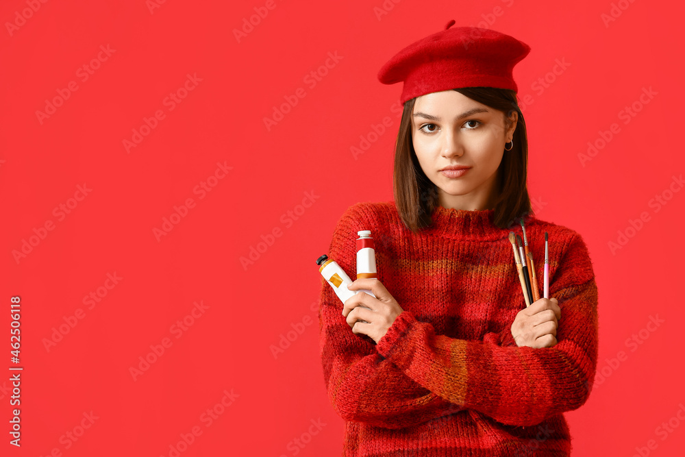 Young female artist on color background