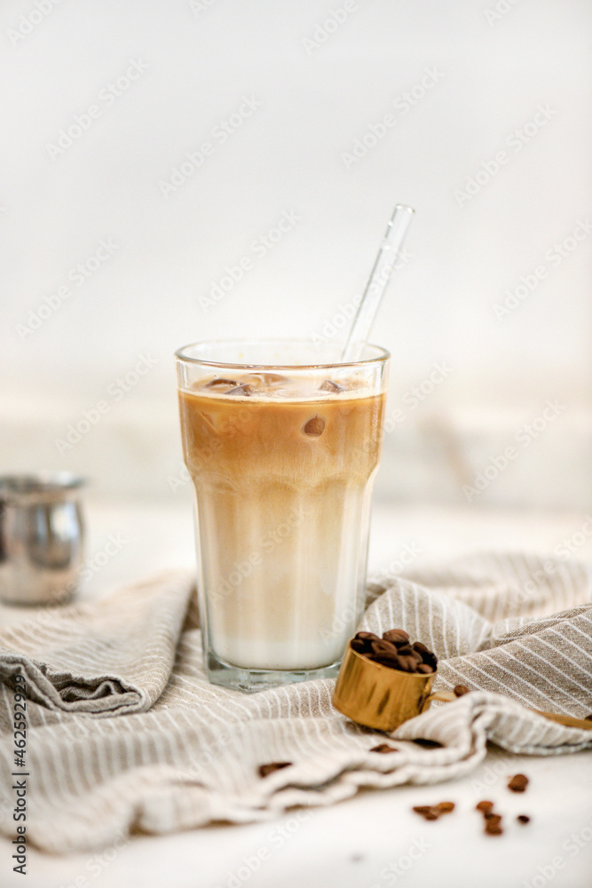 Iced latte coffee drink in tall glass over white background