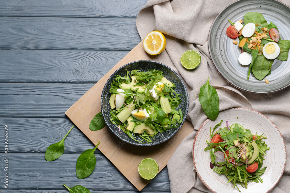 Plates with healthy salad on color wooden background