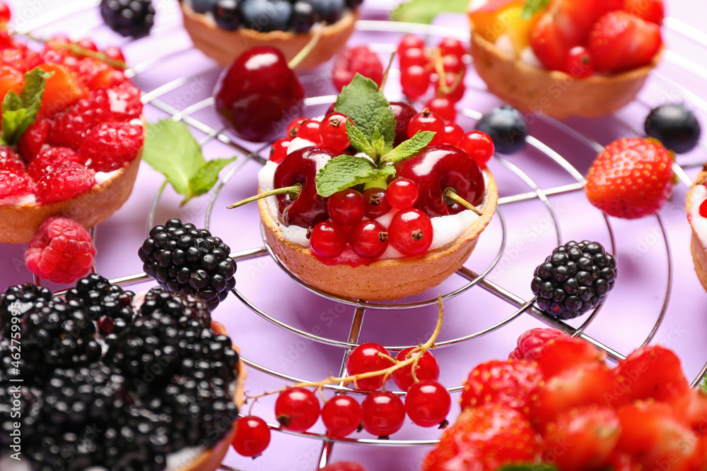 Tasty berry tart on purple background