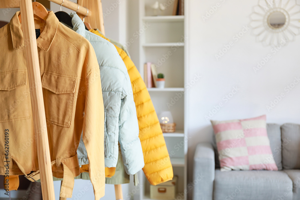 Rack with stylish jackets in modern living room