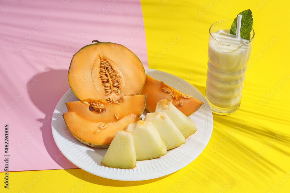 Glass of tasty melon milkshake on color background