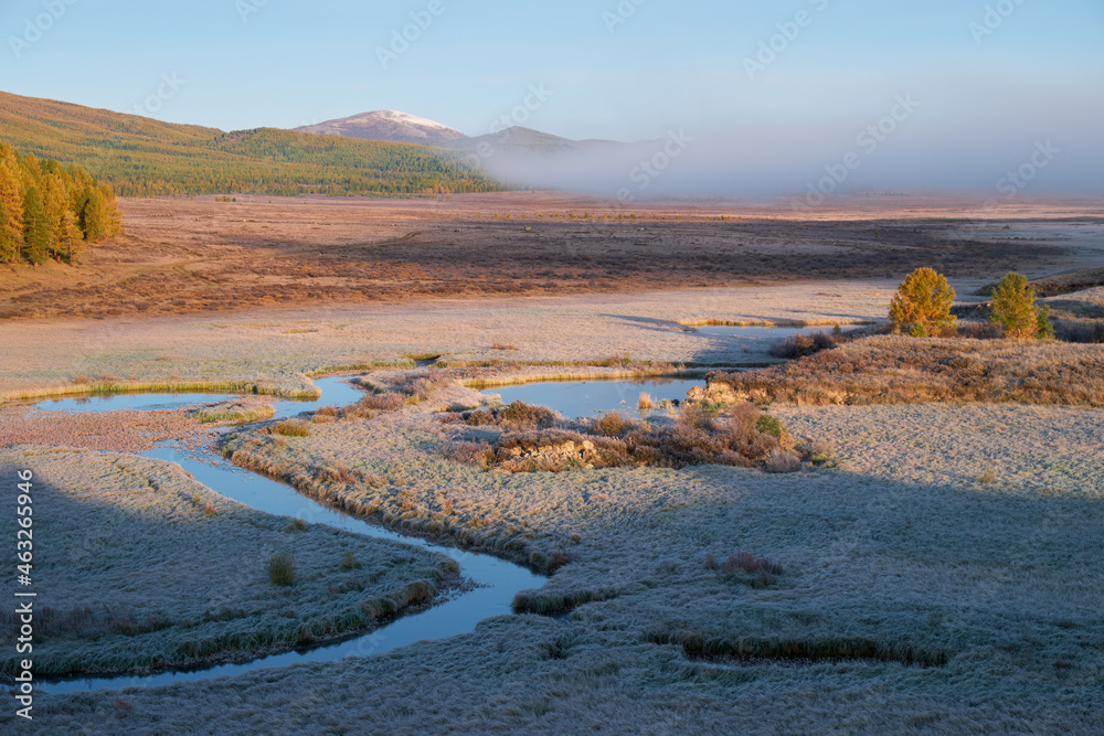 Altai river Kurkurek on Eshtykel plateau covered with morning fog. Grass under hoarfrost.