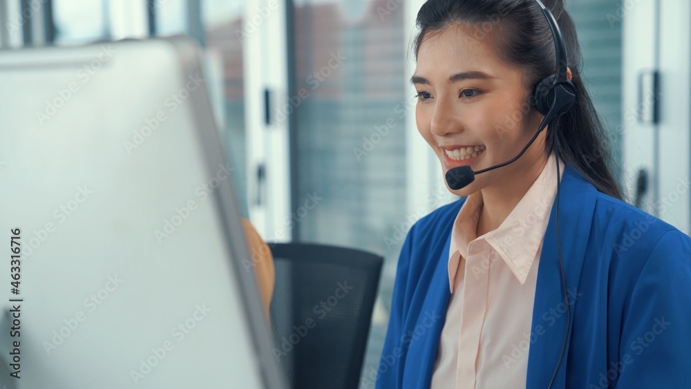 Businesswoman wearing headset working actively in office . Call center, telemarketing, customer supp