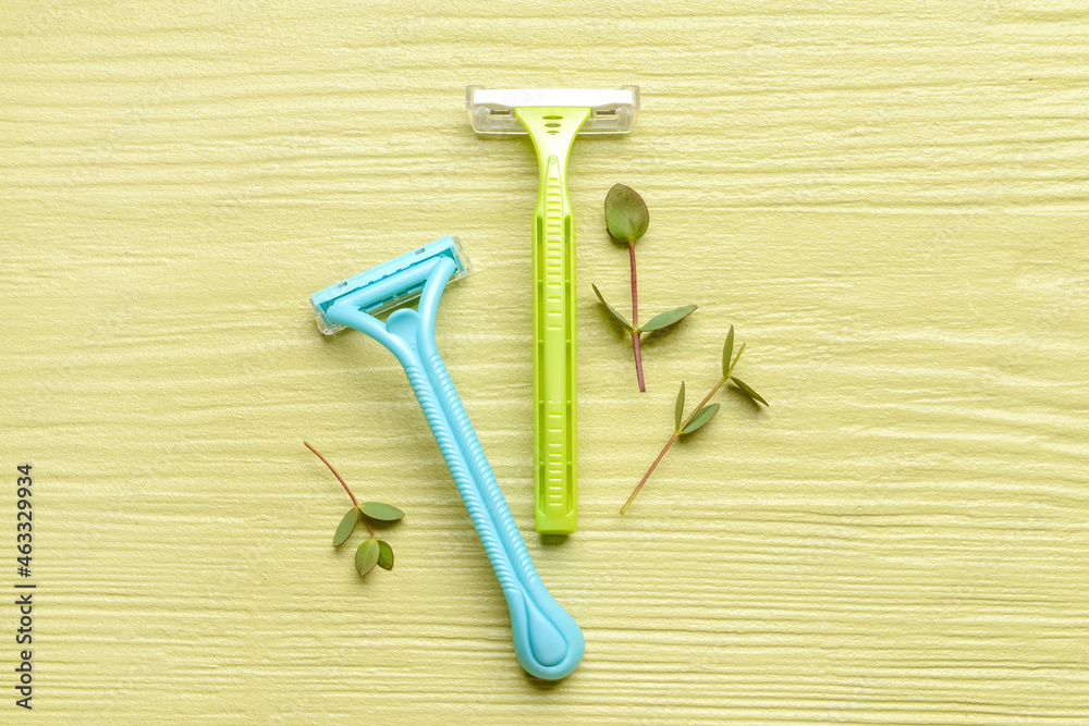 Safety razors on color wooden background