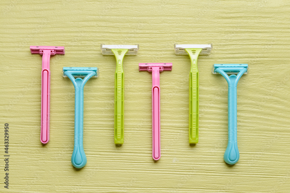 Many different razors for depilation on color wooden background