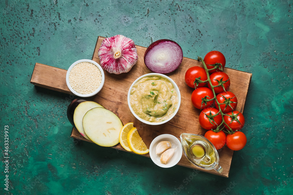 Bowl with tasty baba ghanoush and vegetables on color background