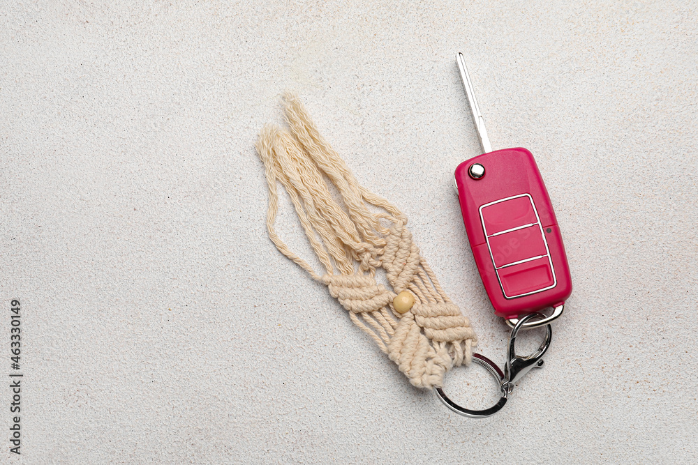 Car key with handmade cotton keychain on light background