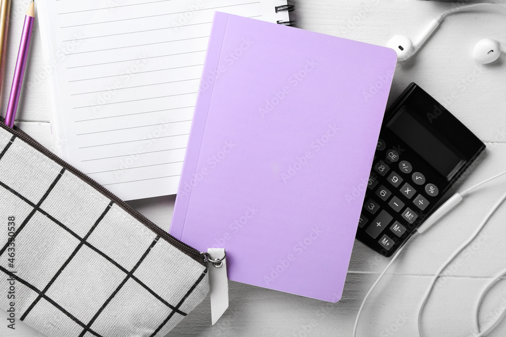 Stationery supplies and earphones on white wooden table, closeup