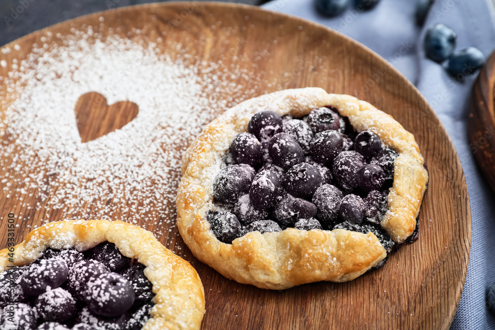 Plate with tasty blueberry galettes on table, closeup