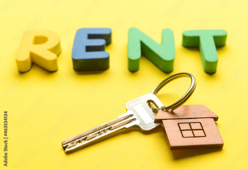 Word RENT with key from house on yellow background，特写